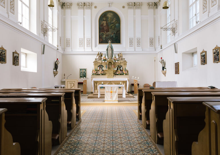 Die Kapelle des Clementinums mit goldenem Altar und Holzbänken.
