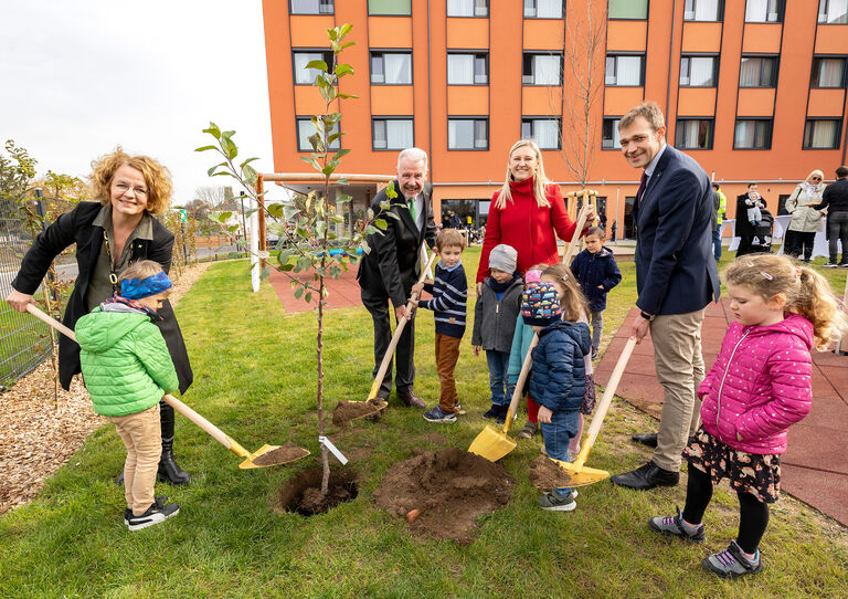 Kindergarteneröffnung Stadtheim Gruppenbild der Politiker, Kindergartenbetreiber und Kindergartenkinder - sie pflanzen einen Baum