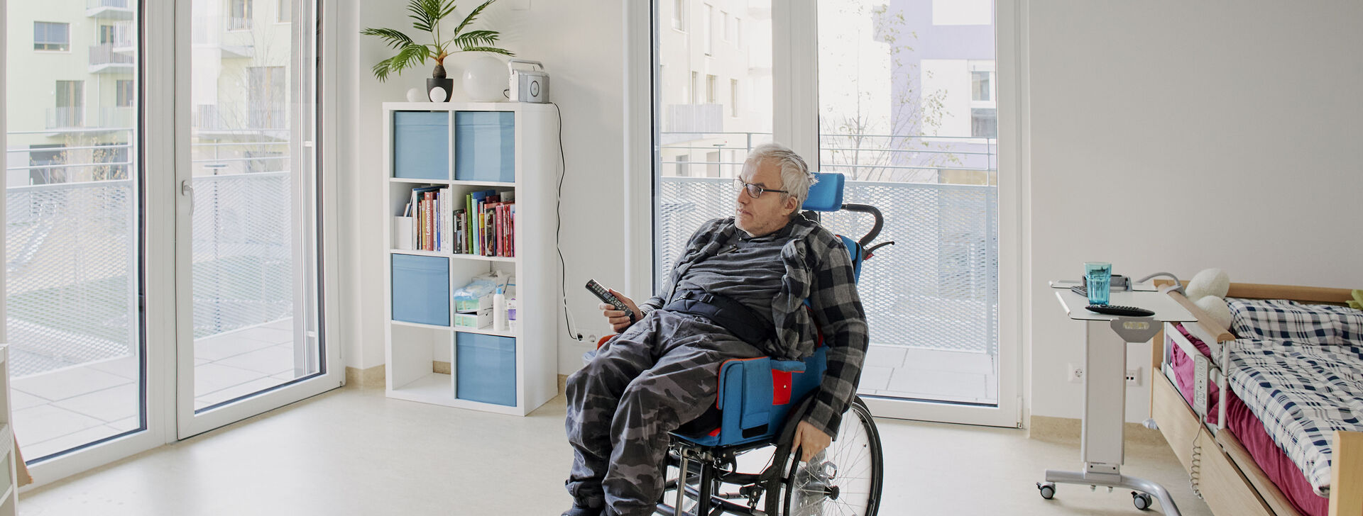 HABIT Kunde in seinem Rollstuhl - Großaufnahme von seinem Zimmer.