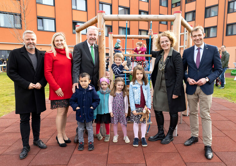 Kindergarteneröffnung Stadtheim Gruppenbild der Politiker, Kindergartenbetreiber und Kindergartenkinder - sie stehen am Spielplatz
